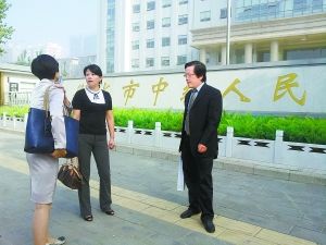 宋雅红（中）开庭前与她的两位律师交谈。（图片来源：北京晚报）