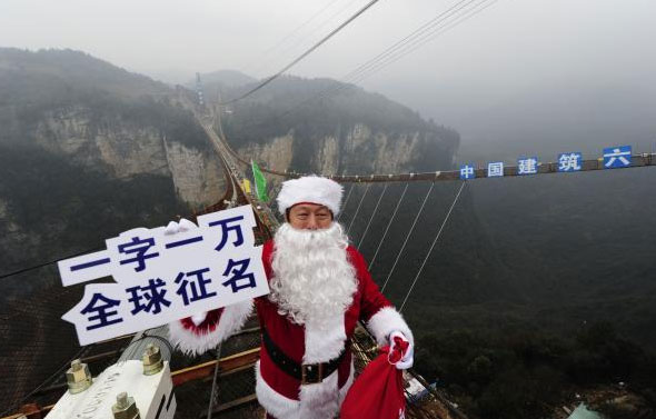 2015年12月20日，湖南张家界，张家界大峡谷景区董事长陈志冬打扮成圣诞老人的形象站在玻璃桥上，拉开向全球征集桥名一字一万元的活动。 视觉中国 图