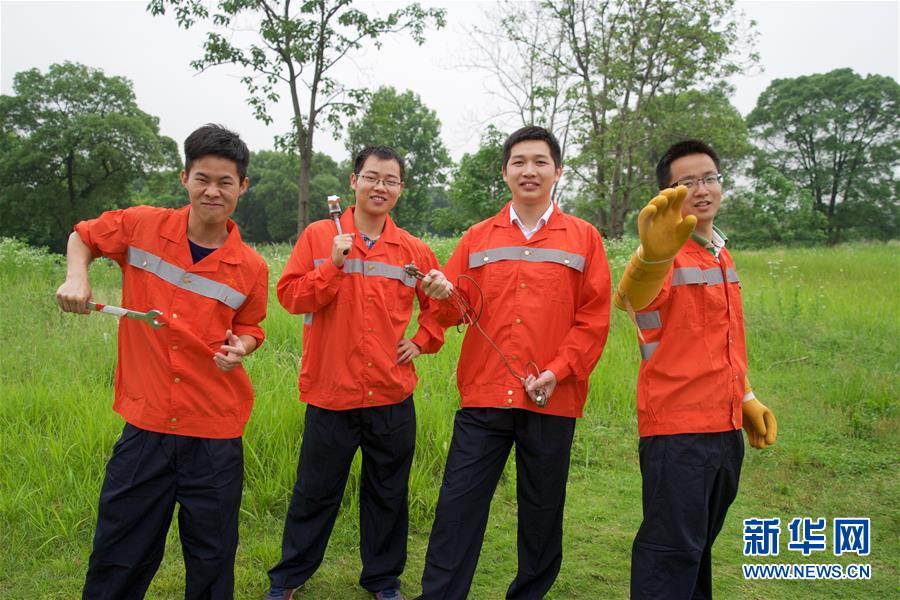 5月24日，江西华东交通大学轨道交通职业学院老师胡建军（中）和即将毕业的学生，身着轨道维护人员制服在校内的铁轨试验场合影。当日，江西华东交通大学的部分学生身着不同职业的工作制服，用“另类”的毕业照留住校园的美好回忆。 新华社记者胡晨欢摄